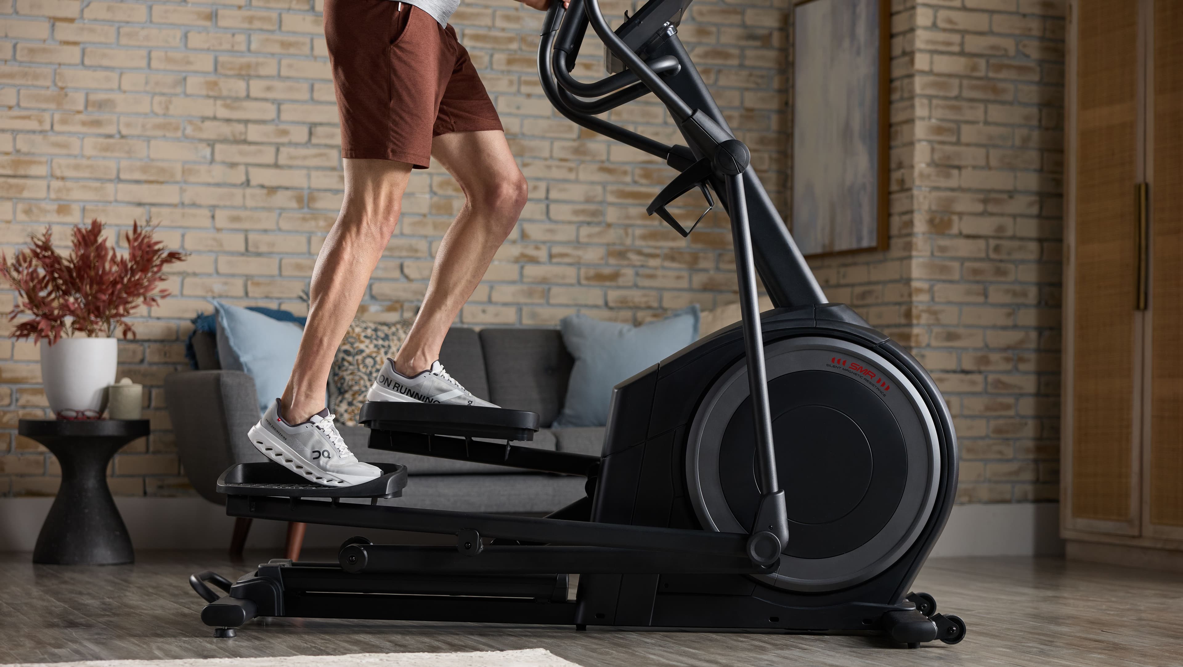 Person using a NordicTrack elliptical trainer at home for a cardio workout. Elliptical training supports fat loss as part of a consistent exercise routine and caloric deficit.
