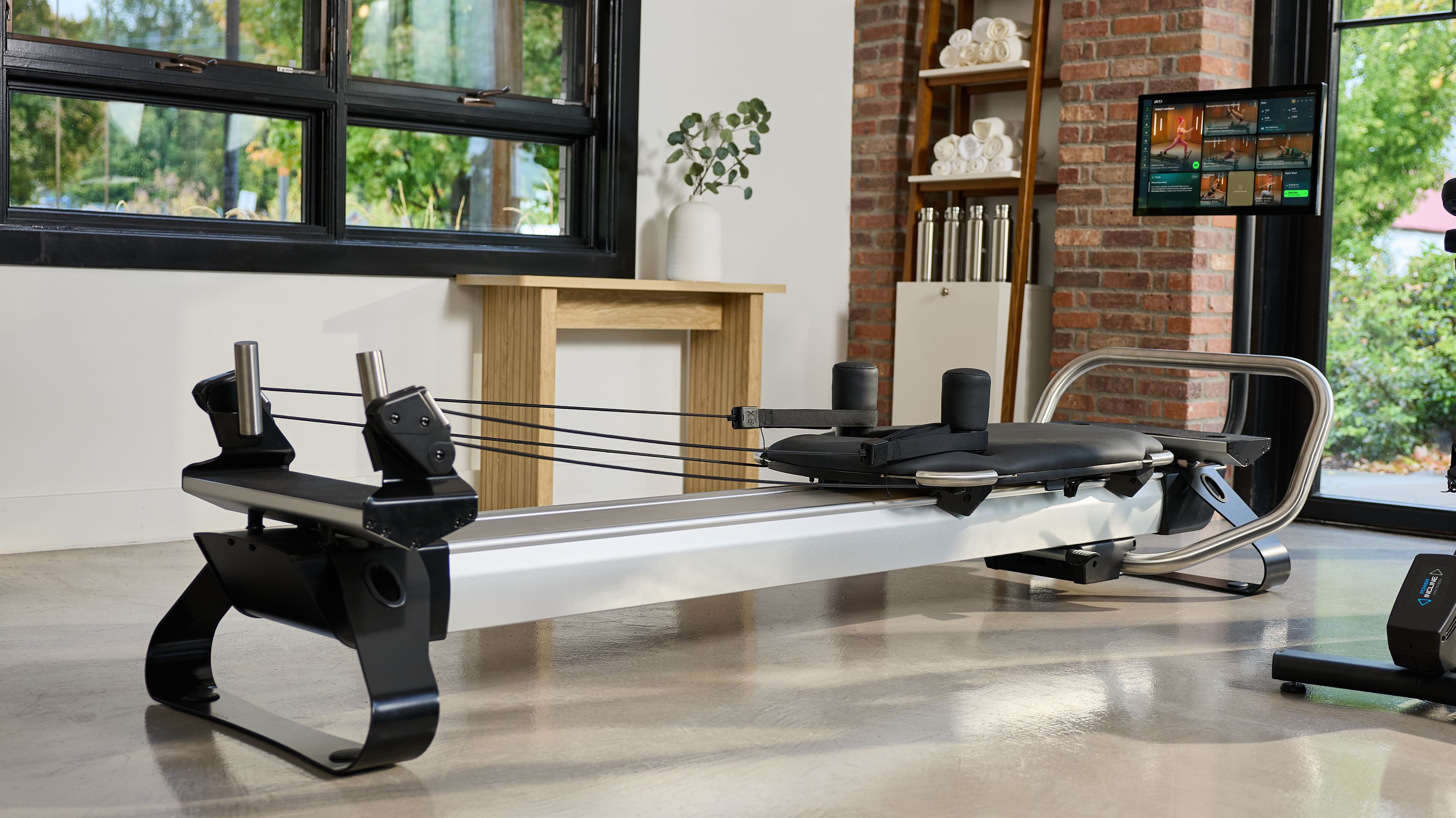 The NordicTrack Ultra 1 Reform RX-S in a premium natural-light studio with iFIT content on screen. The connected reformer PT practices are adding to support self-guided patient sessions, maintenance programming, and clinical Pilates work.