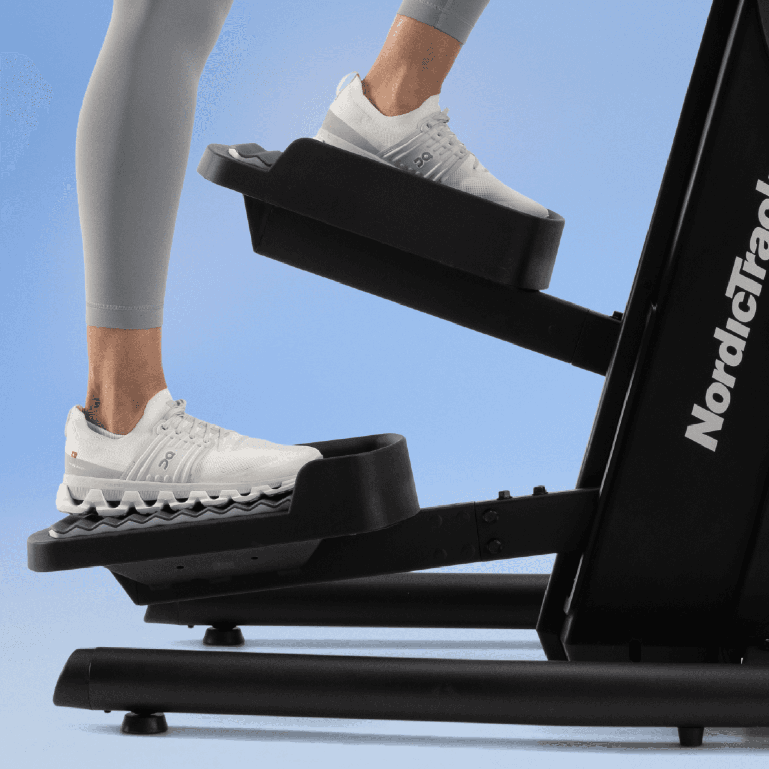 side view of the NordicTrack step climber with a woman on the pedals
