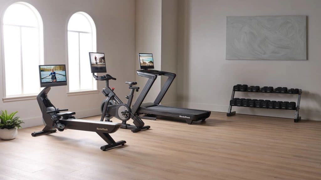 NordicTrack treadmill, rower, and bike displayed in a bright home gym with free weights, showcasing a connected training setup.