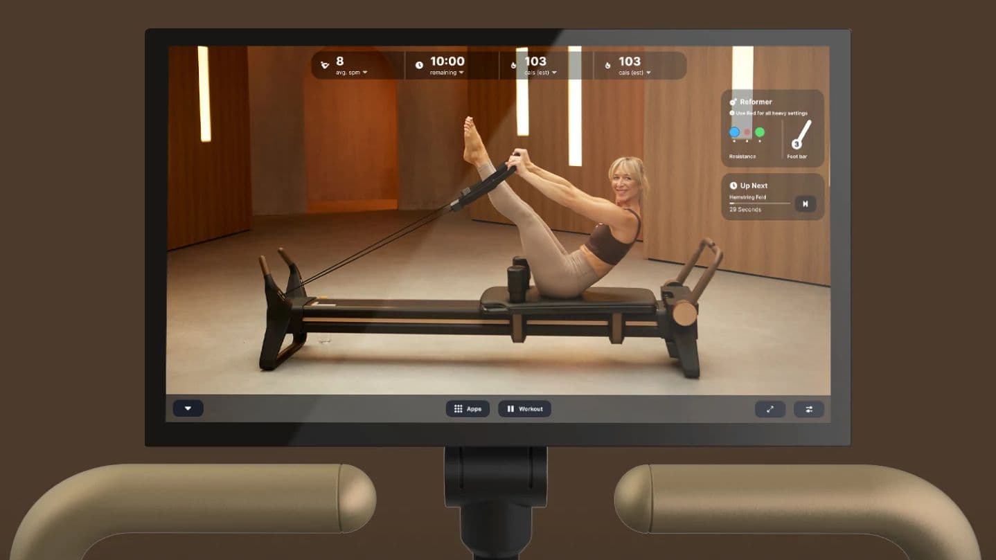 NordicTrack Ultra 1 reformer touchscreen showing a live iFIT Pilates session with real-time Smart Spine metrics, resistance settings, and instructor-led hamstring fold exercise — helping at-home practitioners train with guided precision.